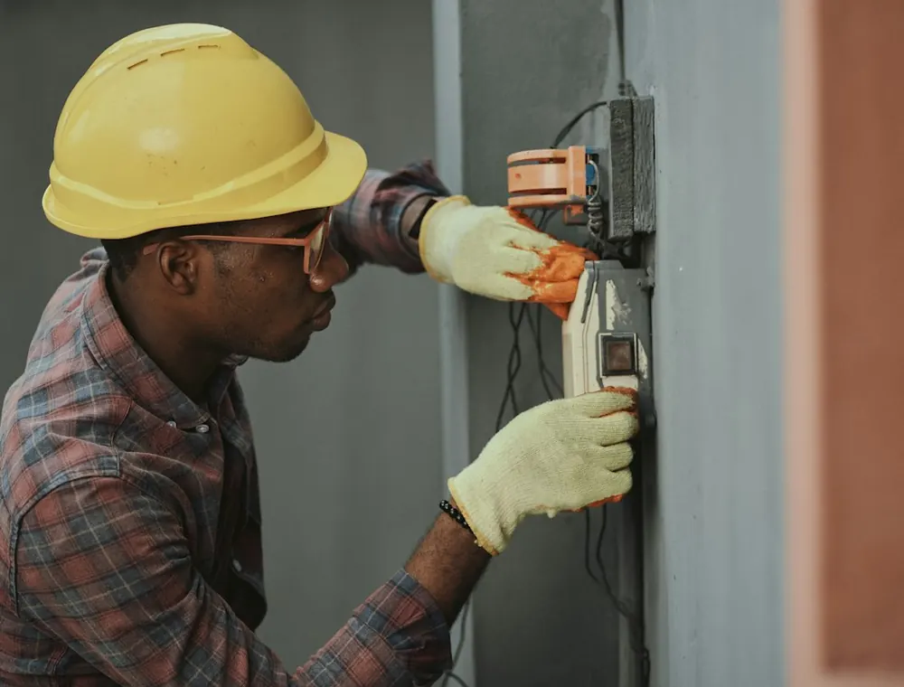 Un técnico con casco trabajando en una instalación eléctrica.